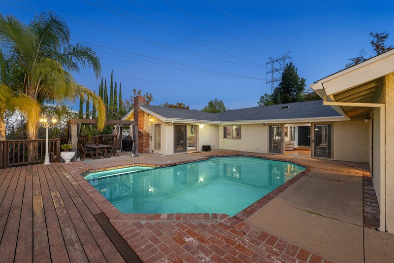 patio con alberca de cemento detrás de una casa de un piso